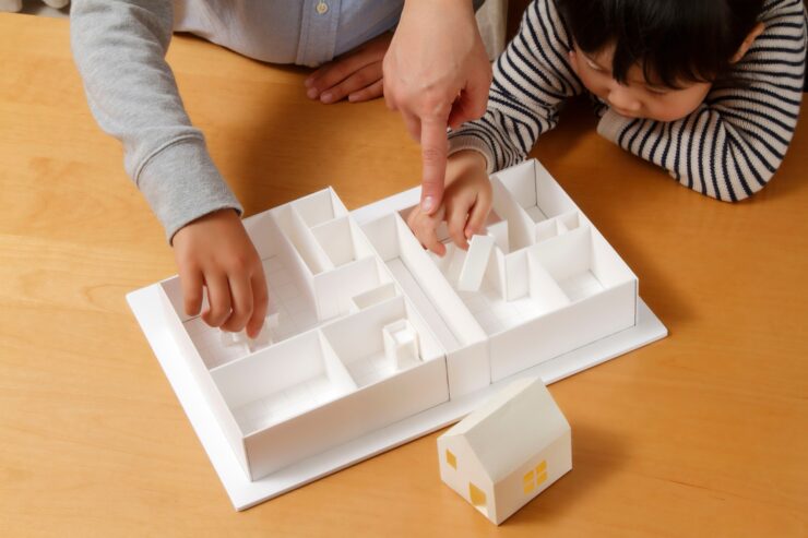 間取り模型を組み替えながら動線を検討する親子のイメージ