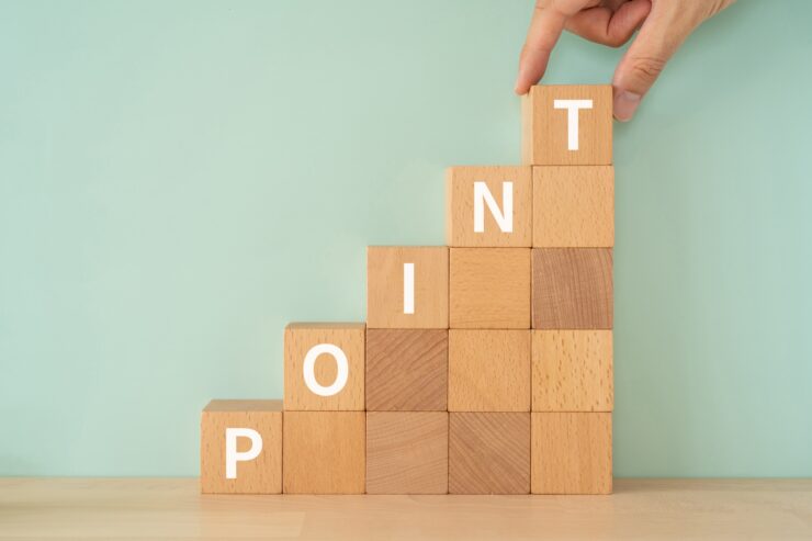 ポイントのイメージ｜「POINT」と書かれたブロックと手 