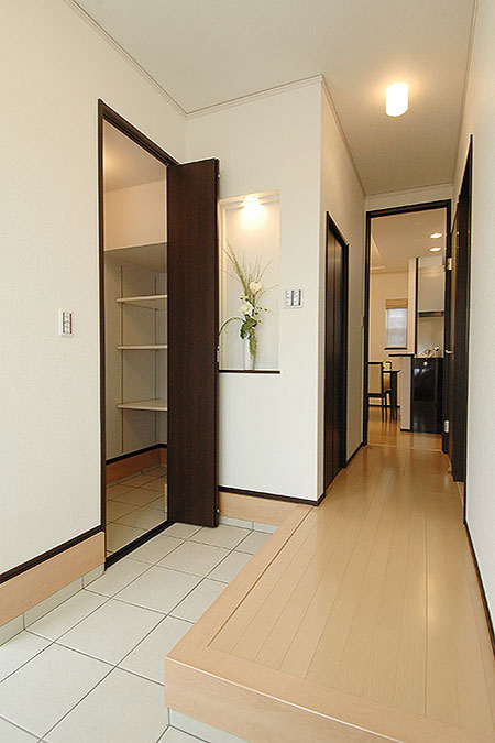 L字型の玄関土間と折れ戸で仕切られたシューズクローク
