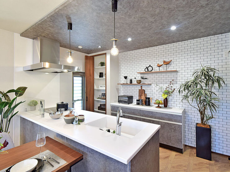 モルタル調とサブウェイタイル調クロスのペニンシュラキッチン