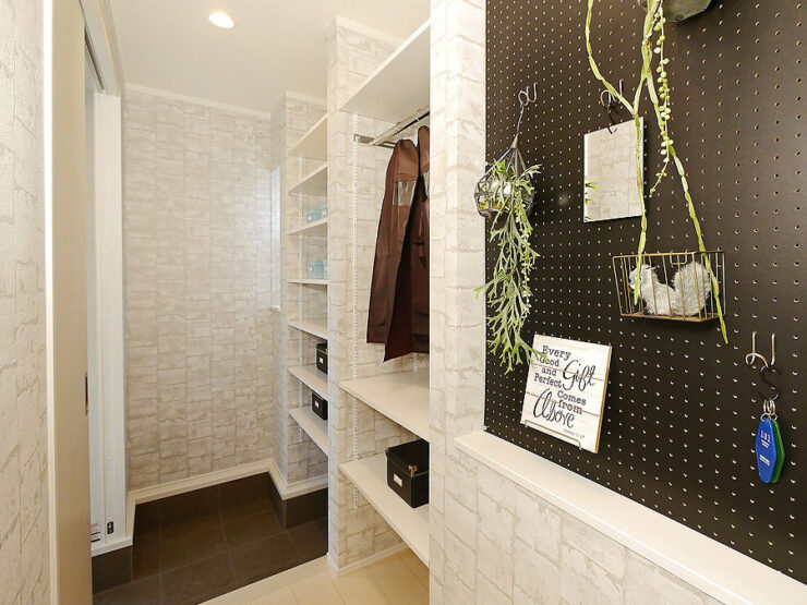 石目柄の壁紙と黒い有孔ボードのクローズドシューズクローク