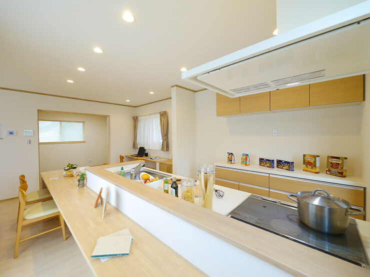 広いカウンターが付いたナチュラルカラーのペニンシュラキッチン