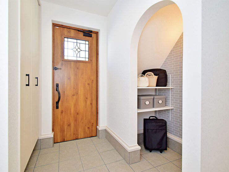 アンティークな木目の玄関ドアとアーチ型のシューズクローク