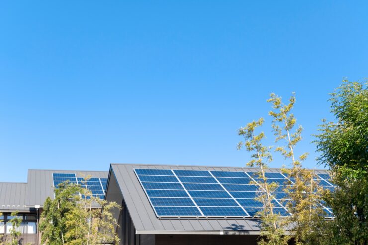 屋根に太陽光パネルが設置された省エネ住宅、上に広がる青空