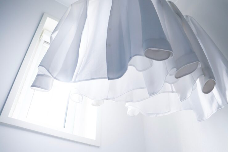 日差しが明るいランドリースペースで白シャツを干す様子