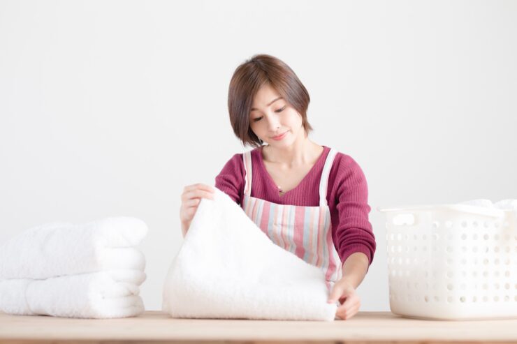 台の上でバスタオルを畳む主婦