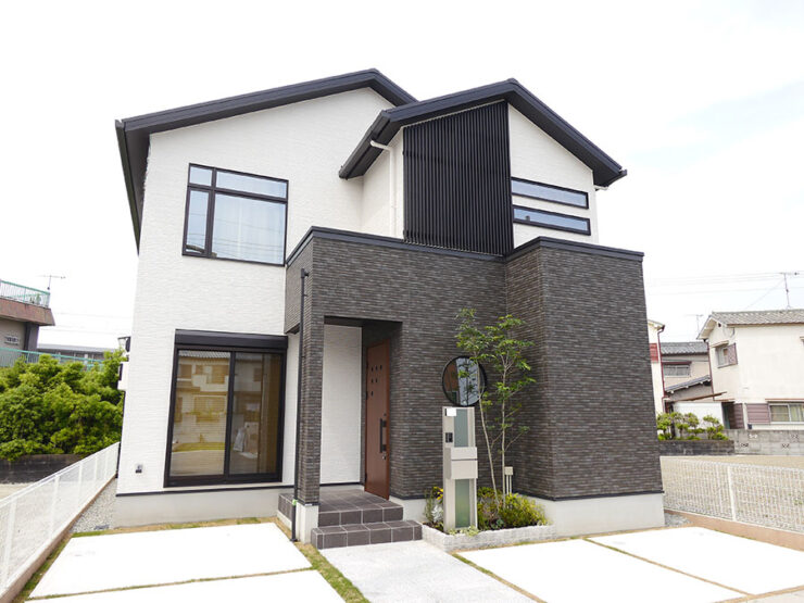白い外壁とアプローチのグレーが印象的な和モダンの住宅外観