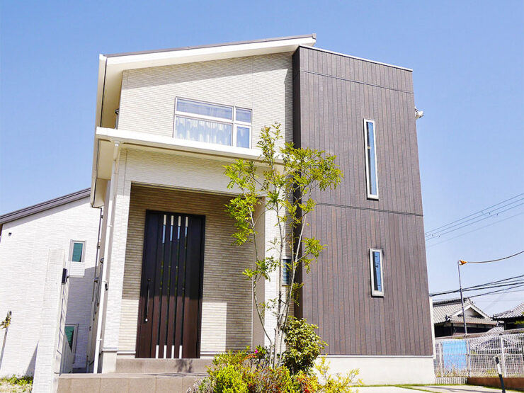 白のタイル調サイディングと木目調サイディングの住宅外観
