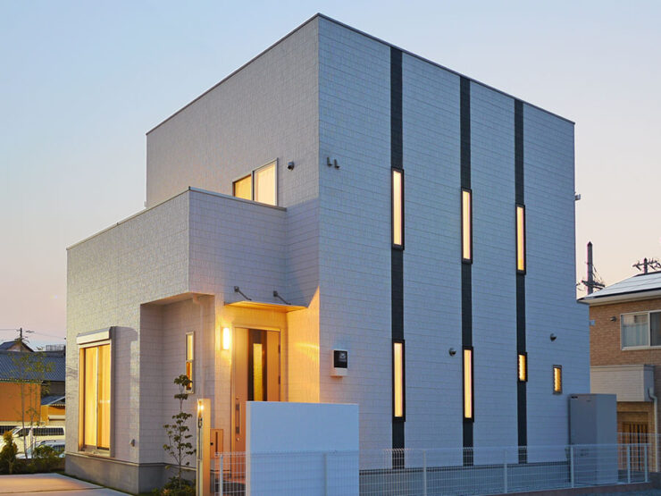 夕焼けに映える白いキューブ状のシンプルモダンな住宅外観