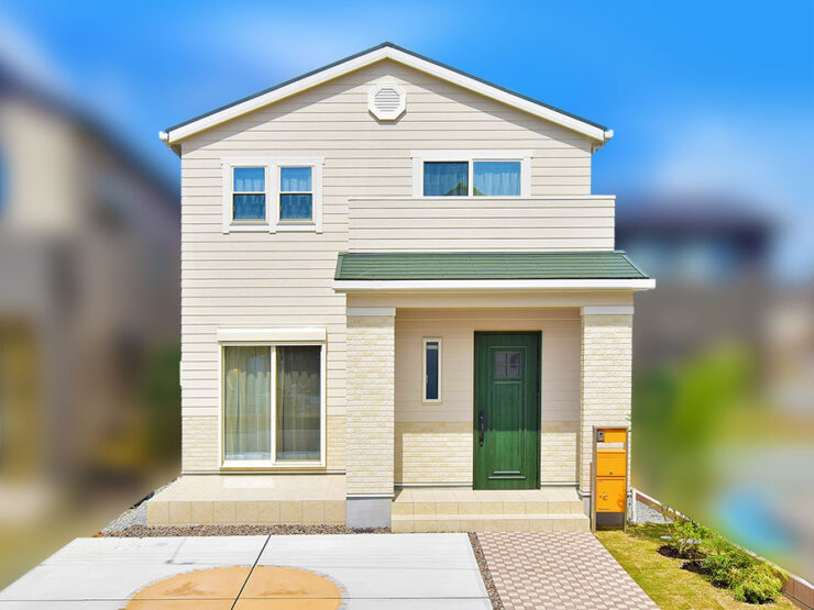 横張りの木目調サイディングとドアや屋根の緑がおしゃれなアメリカンテイストな住宅外観