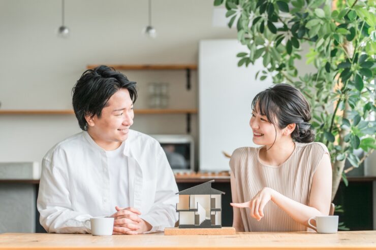 住宅模型を見てマイホームを検討する若い夫婦